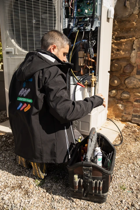 Un technicien utilise une tablette pour inspecter une pompe à chaleur extérieure par beau temps