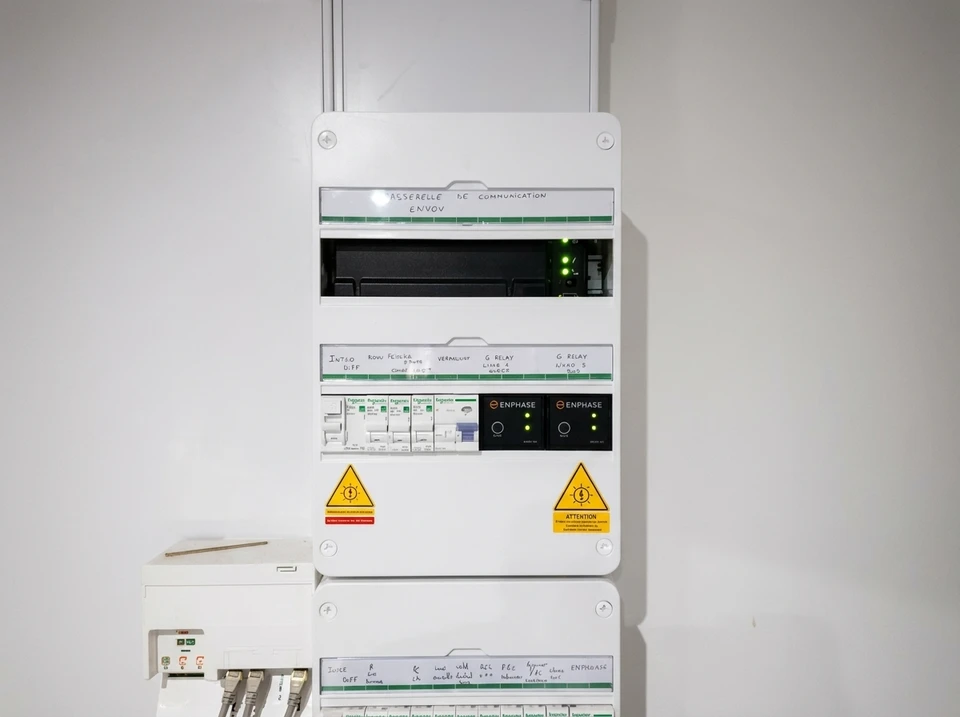 Électricien en intervention à domicile travaillant sur une installation électrique près d'une fenêtre